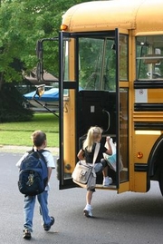 young students getting on bus